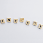 Wooden scrabble tiles are laid out to spell out anxiety