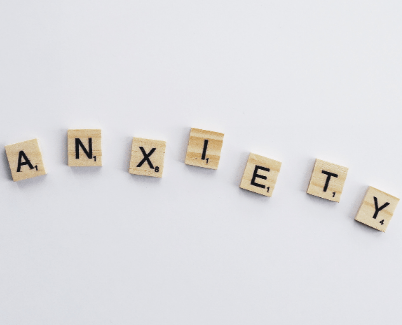 Wooden scrabble tiles are laid out to spell out anxiety