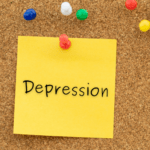 A photo of a post-it on a corkboard that says depression