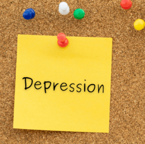 A photo of a post-it on a corkboard that says depression